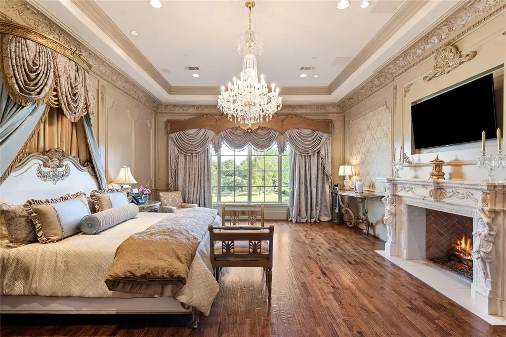 Château Lumièr in McKinney Lists for $14.65 Million as a French Chateau Estate Spanning Fifteen Wooded Acres 8 Primary suite inside Château Lumièr at 1201 Gray Branch Rd in McKinney featuring a crystal chandelier carved fireplace elegant drapery and expansive garden views.