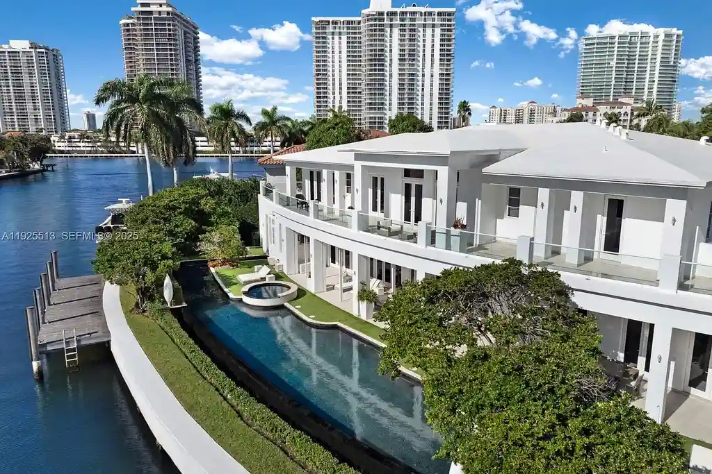 Aerial view of the luxurious $18,900,000 waterfront estate at 142 S Island in Golden Beach, showcasing private dock, expansive pool, and modern architectural design.