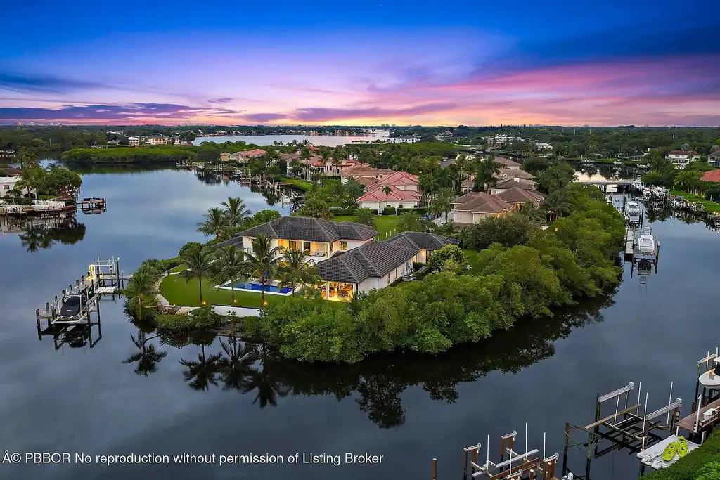 A $13 Million Peninsula Estate Redefines Waterfront Luxury Living in Jupiter, Florida 5 Waterfront backyard of a luxury home in Jupiter for sale, featuring a private dock and resort-style outdoor living