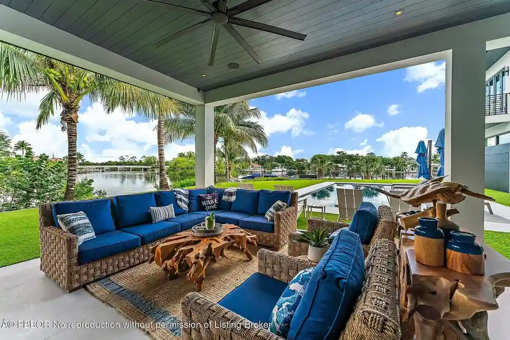 A $13 Million Peninsula Estate Redefines Waterfront Luxury Living in Jupiter, Florida 17 Waterfront backyard of a luxury home in Jupiter for sale, featuring a private dock and resort-style outdoor living