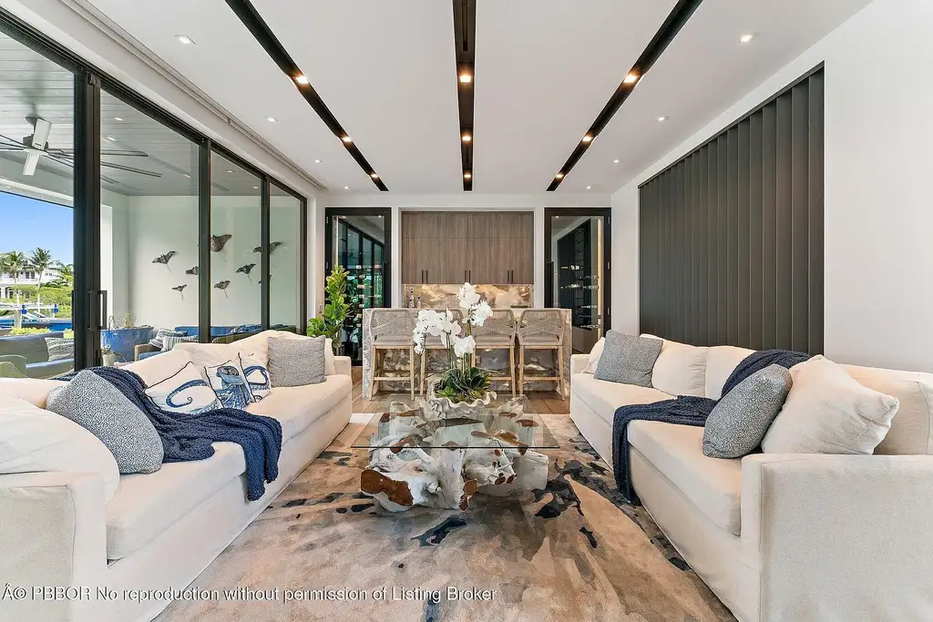 A $13 Million Peninsula Estate Redefines Waterfront Luxury Living in Jupiter, Florida 7 Waterfront backyard of a luxury home in Jupiter for sale, featuring a private dock and resort-style outdoor living