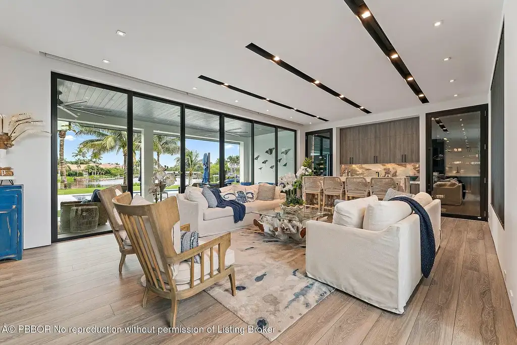 A $13 Million Peninsula Estate Redefines Waterfront Luxury Living in Jupiter, Florida 6 Waterfront backyard of a luxury home in Jupiter for sale, featuring a private dock and resort-style outdoor living