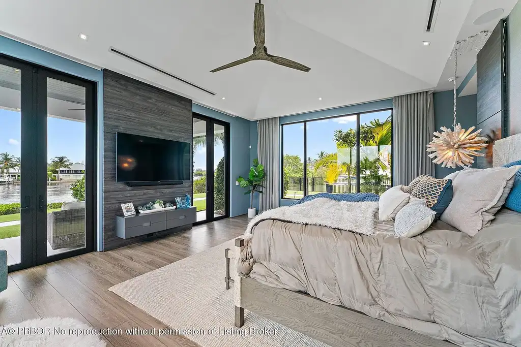 A $13 Million Peninsula Estate Redefines Waterfront Luxury Living in Jupiter, Florida 11 Waterfront backyard of a luxury home in Jupiter for sale, featuring a private dock and resort-style outdoor living