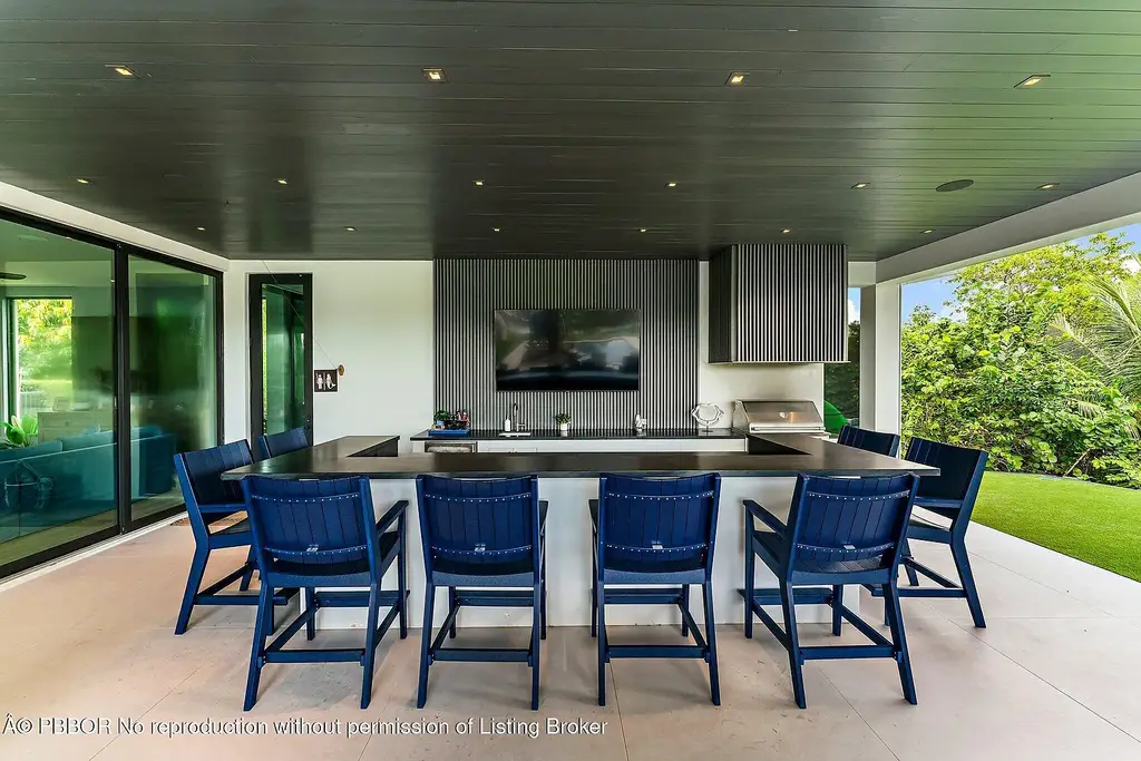 A $13 Million Peninsula Estate Redefines Waterfront Luxury Living in Jupiter, Florida 16 Waterfront backyard of a luxury home in Jupiter for sale, featuring a private dock and resort-style outdoor living