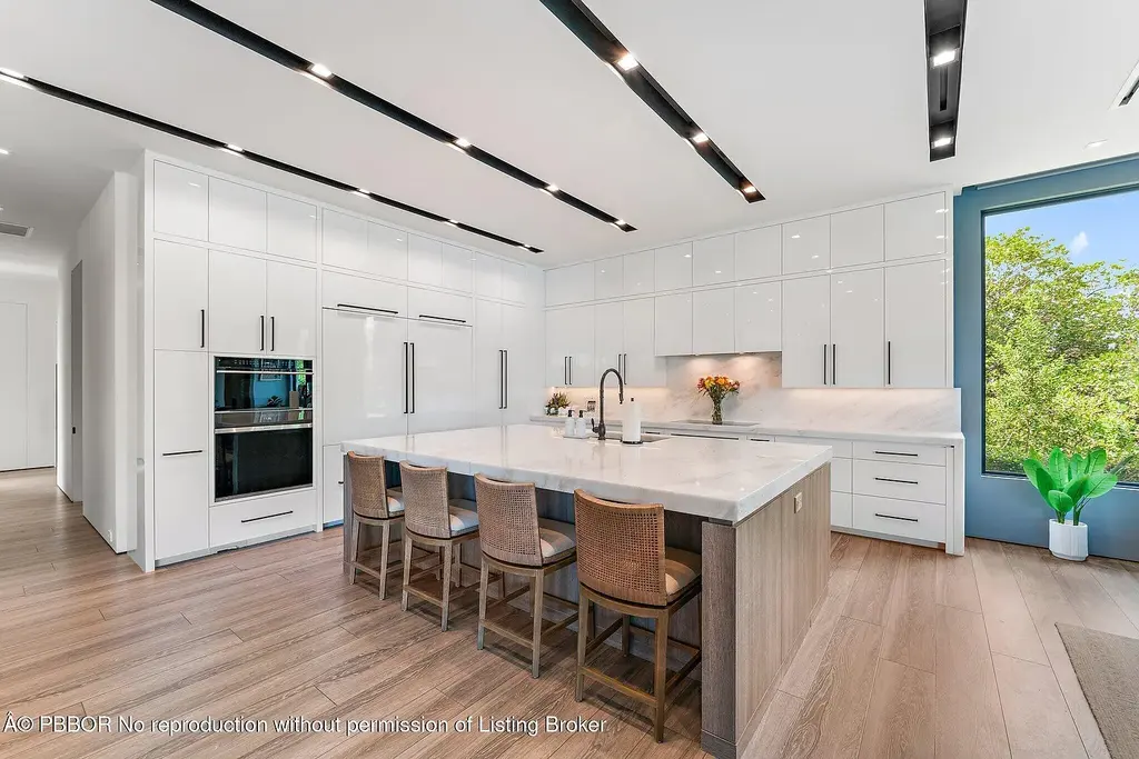 A $13 Million Peninsula Estate Redefines Waterfront Luxury Living in Jupiter, Florida 9 Waterfront backyard of a luxury home in Jupiter for sale, featuring a private dock and resort-style outdoor living