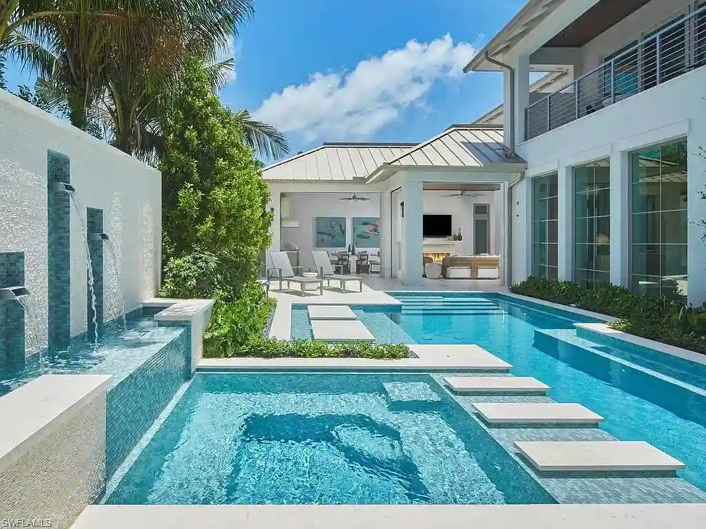 A $19.9 Million Stunning Tropical Contemporary Estate Steps From the Beach in Prestigious Naples 17 Tropical contemporary exterior of 2075 Gordon Dr E in Naples FL featuring a metal roof, stone accents, and lush landscaping near the beach
