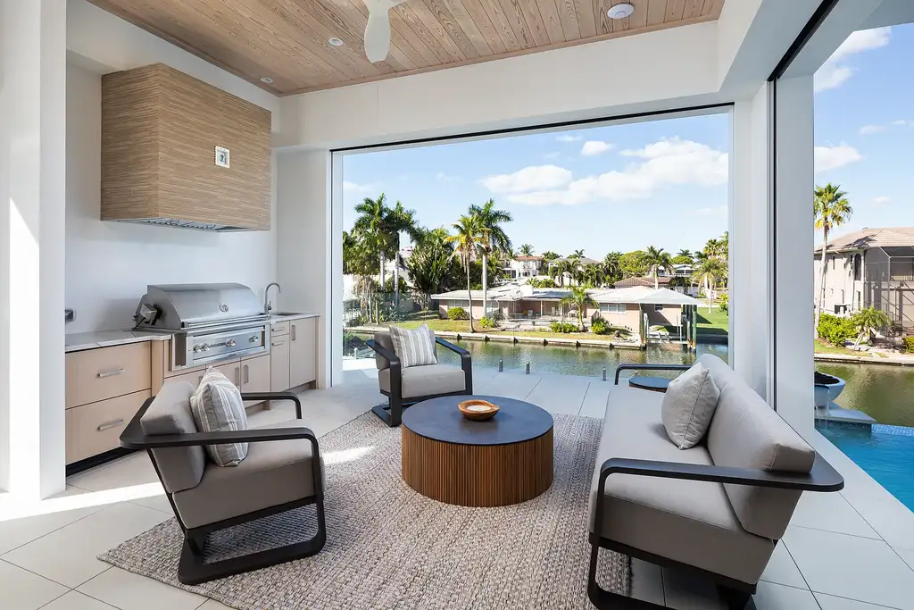 Interior and exterior views of 223 Bayview Avenue Naples FL showing 6-bedroom waterfront estate with modern coastal design, infinity pool, elevated terrace, and private dock.