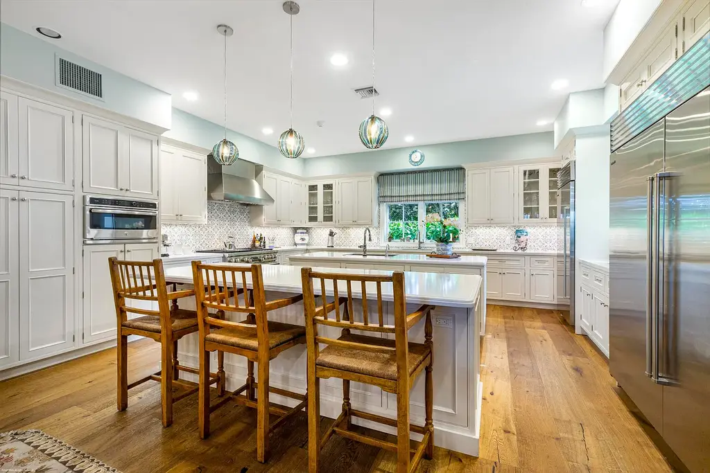 $13.5 Million Luxury Wellington Estate Featuring Private Tennis Court, Pool, and Equestrian Amenities 9 Outdoor pool and cabana at 2359 Muir Circle, Wellington, surrounded by manicured gardens and private tennis court