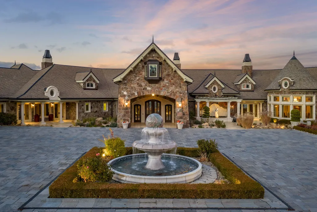 The Pennington Mansion at 2490 Manzanita Ln Hits the Market for $13,950,000, Introducing One of Reno’s Most Spectacular Trophy Estates 14 Twilight view of the Pennington Mansion front entrance featuring a stone façade illuminated by warm lighting and a central tiered fountain.