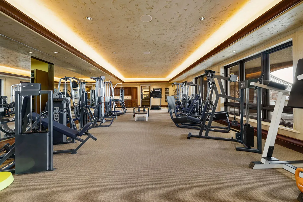 The Pennington Mansion at 2490 Manzanita Ln Hits the Market for $13,950,000, Introducing One of Reno’s Most Spectacular Trophy Estates 12 Expansive home gym at the Pennington Mansion featuring multiple strength and cardio machines mirrored walls and soft lighting along the ceiling.