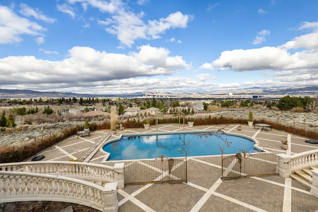The Pennington Mansion at 2490 Manzanita Ln Hits the Market for $13,950,000, Introducing One of Reno’s Most Spectacular Trophy Estates 16 Elevated view of the Pennington Mansion pool terrace overlooking Reno and the distant mountains under a bright sky.