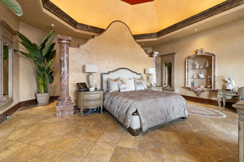 The Pennington Mansion at 2490 Manzanita Ln Hits the Market for $13,950,000, Introducing One of Reno’s Most Spectacular Trophy Estates 5 Primary suite at the Pennington Mansion featuring ornate columns textured walls elegant furnishings and a sculpted headboard beneath a dramatic ceiling.