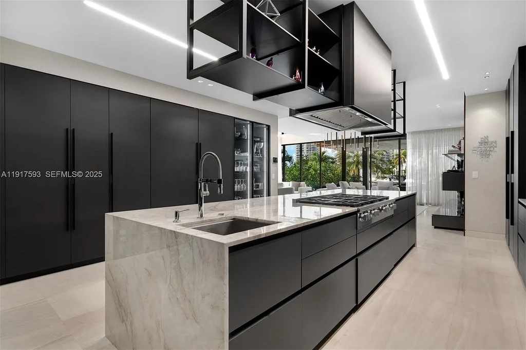 Exquisite $16.9 Million Modern Waterfront Estate in North Miami Beach Offers Unmatched Luxury and Elegance 10 Interior view of 342 S Pkwy showcasing open-plan living area, Mia Cucina kitchen, and luxury limestone flooring