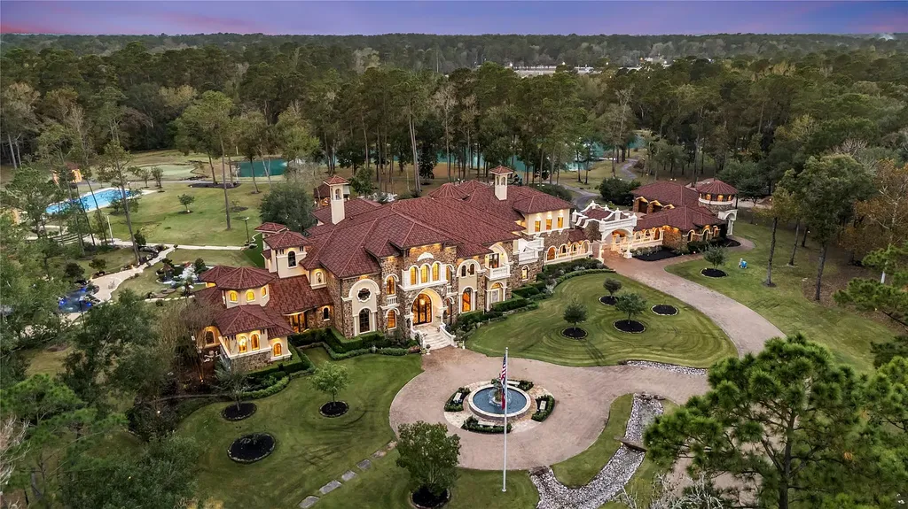 A Mediterranean Masterpiece Rising Above the Woodlands of Magnolia, Texas Seeks for $11,500,000 15 Aerial view of the Mediterranean mansion at 38262 Windy Ridge Trail in Magnolia, Texas, showcasing the grand front elevation, circular drive with fountain, landscaped lawns, and surrounding wooded acreage.