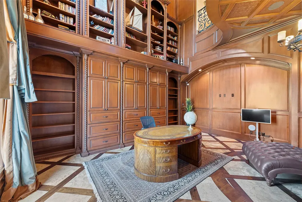 A Mediterranean Masterpiece Rising Above the Woodlands of Magnolia, Texas Seeks for $11,500,000 7 Luxurious wood-paneled home office and library at 38262 Windy Ridge Trail in Magnolia, Texas, featuring floor-to-ceiling built-ins, an oval executive desk, ornate millwork, and marble-inlaid flooring.