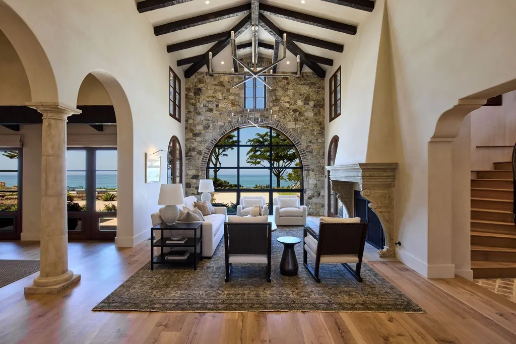 Oceanfront Masterwork Listed at 43 Million Presents One of Southern California’s Most Extraordinary Blufftop Estates 4 Great room of the oceanfront estate at 4130 Calle Isabella in San Clemente featuring vaulted ceilings, stone arch window, ocean views, and Mediterranean architectural details.