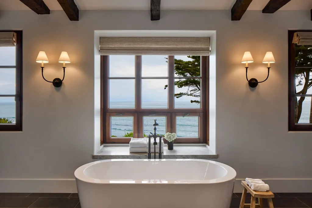 Oceanfront Masterwork Listed at 43 Million Presents One of Southern California’s Most Extraordinary Blufftop Estates 8 Freestanding soaking tub in the oceanfront spa bathroom at 4130 Calle Isabella with coastal views framed by wood-trimmed windows and elegant wall sconces.
