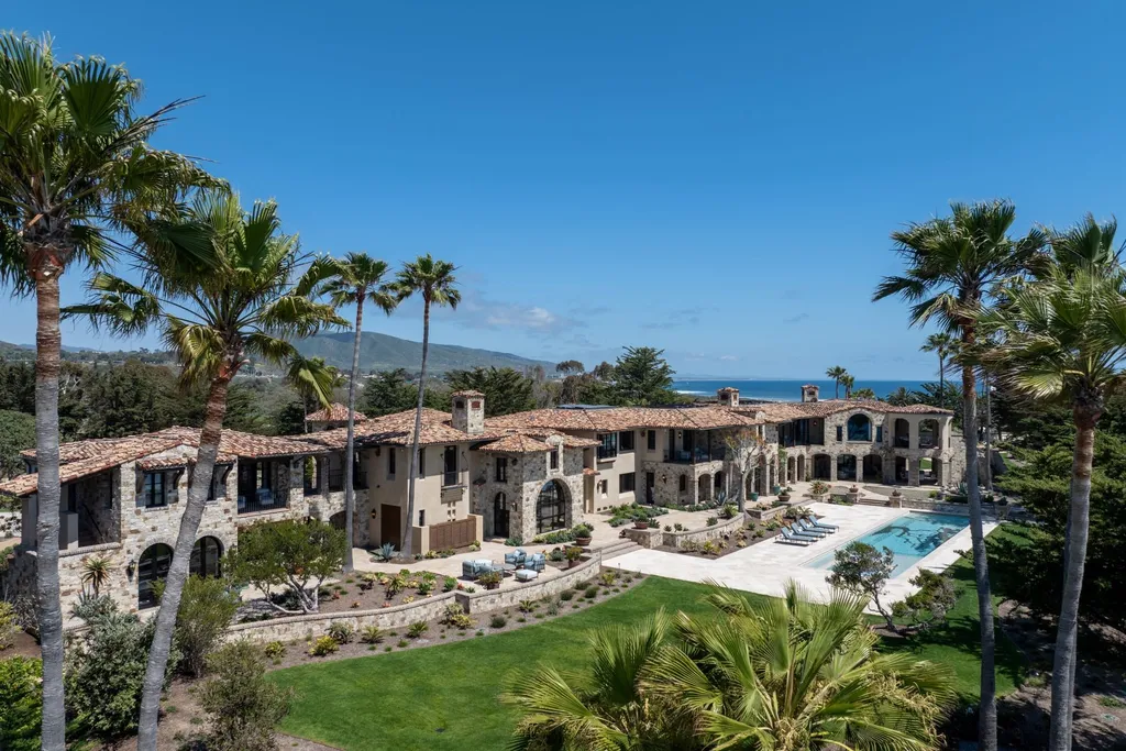 Oceanfront Masterwork Listed at 43 Million Presents One of Southern California’s Most Extraordinary Blufftop Estates 2 Exterior view of the Mediterranean oceanfront estate at 4130 Calle Isabella in San Clemente featuring stone architecture, palm trees, manicured grounds, and a resort style pool.