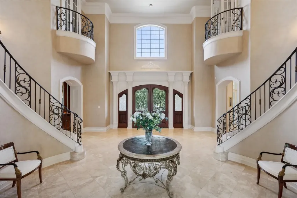 A $6.975 Million Steel Framed Estate Anchors Tour 18’s Most Enduring Address 3 Grand double height foyer with dual curved staircases inside the steel framed estate at 5700 Masters Ct in Flower Mound, Texas