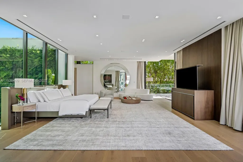 Waterfront exterior view of a tropical modern luxury residence at 6480 Allison Rd in Miami Beach, featuring floor-to-ceiling glass, resort-style pool, and bayfront access.