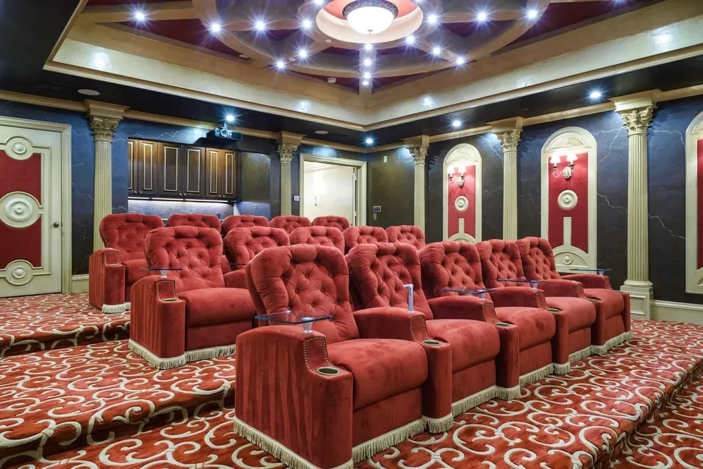 A Venetian Inspired Plano Estate Lists for 7.5 Million as a Rare Architectural Masterpiece in Kings Gate 6 Home theater inside the Venetian inspired estate at 6509 Sudbury Rd in Plano featuring red tufted seating tiered floors decorative columns and cinematic lighting.