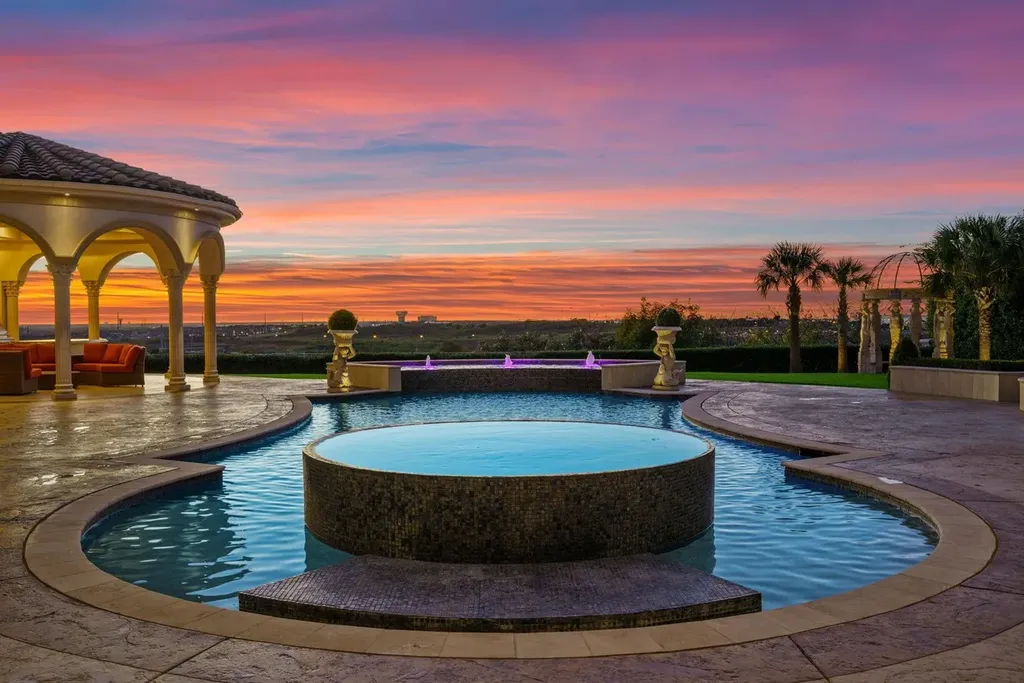 A Venetian Inspired Plano Estate Lists for 7.5 Million as a Rare Architectural Masterpiece in Kings Gate 10 Infinity edge pool and elevated spa at the Venetian inspired estate at 6509 Sudbury Rd in Plano with sunset views palm trees and elegant Mediterranean architecture.