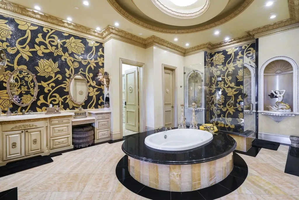 A Venetian Inspired Plano Estate Lists for 7.5 Million as a Rare Architectural Masterpiece in Kings Gate 8 Primary bathroom inside the Venetian inspired estate at 6509 Sudbury Rd in Plano featuring a central soaking tub black and gold mosaic walls ornate vanities and decorative lighting.