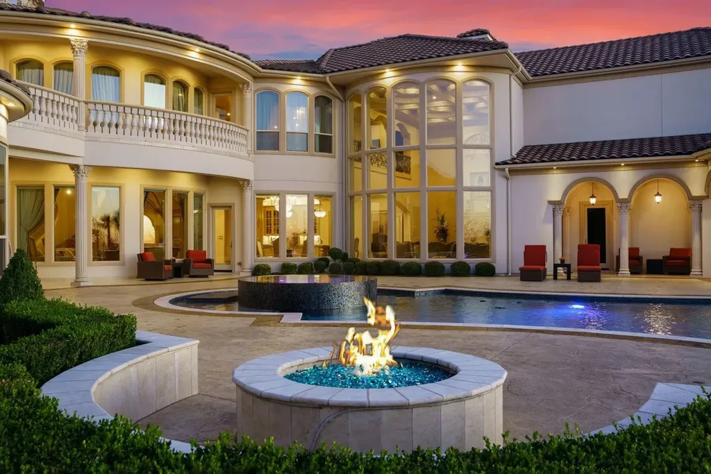 A Venetian Inspired Plano Estate Lists for 7.5 Million as a Rare Architectural Masterpiece in Kings Gate 9 Resort style backyard of the Venetian inspired estate at 6509 Sudbury Rd in Plano featuring a pool spa fire feature arched loggias and dramatic architectural lighting at sunset.