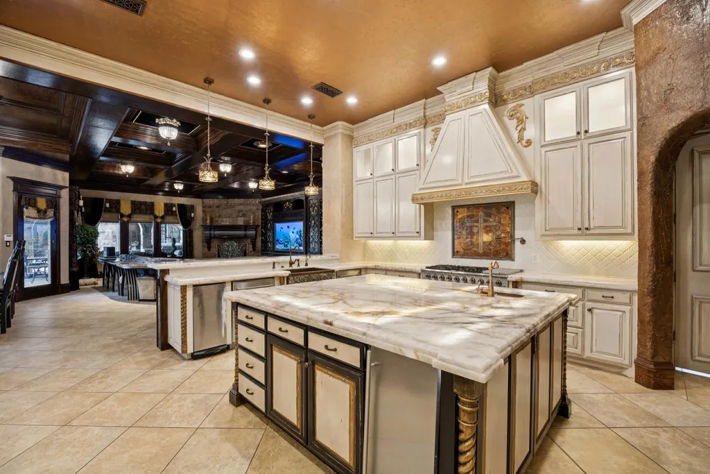 Castle Estate Heads to Auction at 6 Million as a Hilltop Masterpiece in Fort Worth 7 Gourmet kitchen at 9553 Bella Terra Dr Fort Worth Texas featuring marble island custom cabinetry ornate range hood recessed lighting and luxury entertaining space