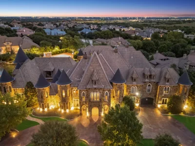 Castle Estate Heads to Auction at 6 Million as a Hilltop Masterpiece in Fort Worth 1 Aerial dusk view of the castle estate at 9553 Bella Terra Dr in Fort Worth Texas showcasing turrets stone architecture and hilltop setting in Montserrat