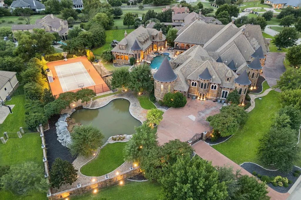 Castle Estate Heads to Auction at 6 Million as a Hilltop Masterpiece in Fort Worth 1 Aerial view of the castle estate at 9553 Bella Terra Dr Fort Worth Texas featuring a private pond tennis court resort style pool and expansive landscaped grounds