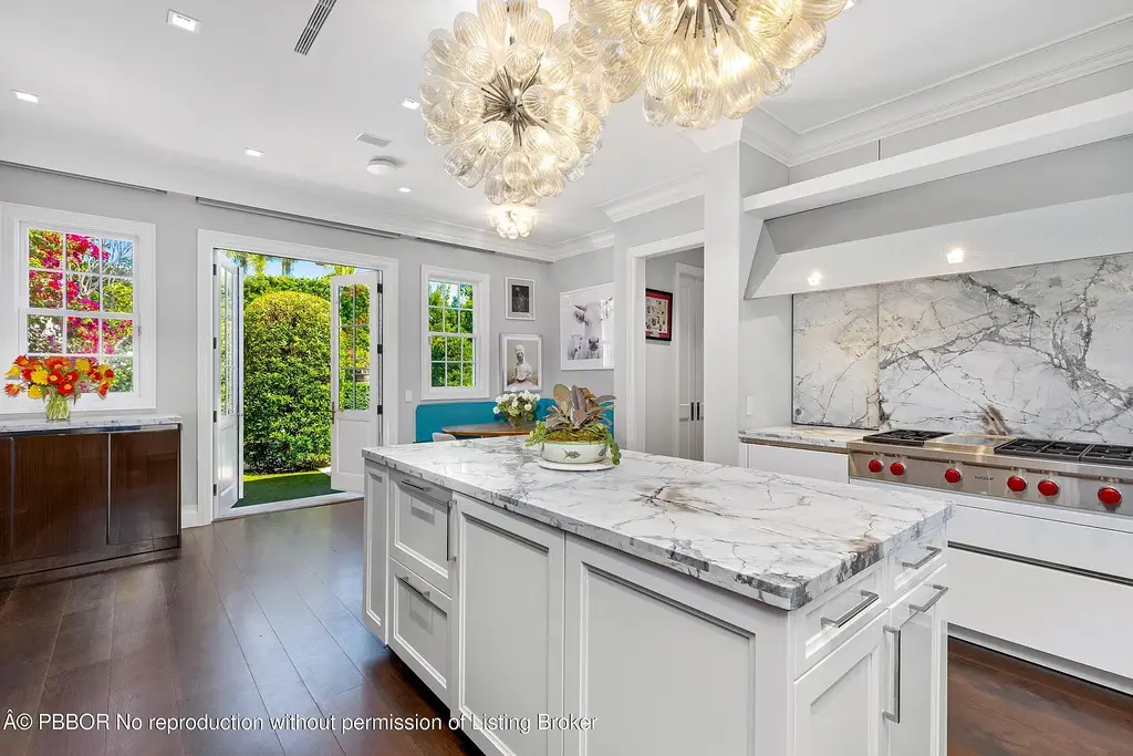 $26.9 Million North End Palm Beach Estate With Guest House and Resort-Style Grounds 10 Front exterior of 1053 N Lake Way, a luxury Palm Beach home for sale featuring Bermuda-style architecture and lush tropical landscaping.