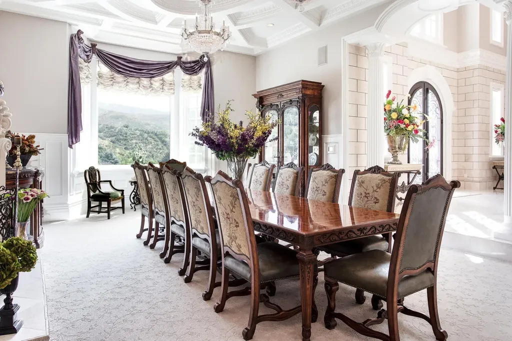 Hobble Creek Ranch: A 3,387-Acre Legacy Estate in Springville, Utah, Asking $38 Million 6 Formal dining room at Hobble Creek Ranch featuring a long carved wood dining table, upholstered chairs, coffered ceiling, crystal chandelier, and expansive windows overlooking Hobble Creek Canyon in Springville, Utah.