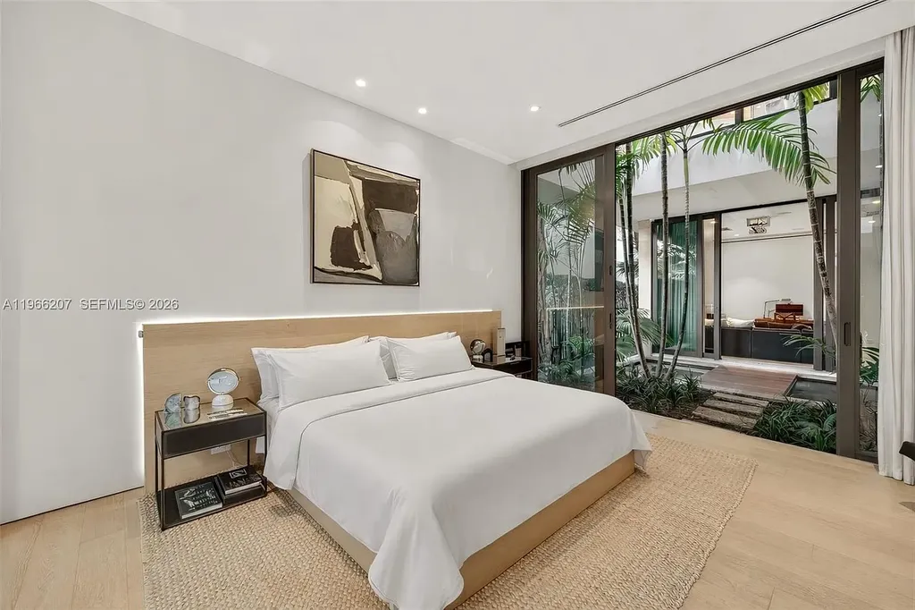 Stunning $14.6 Million Tropical Modern Island Estate Showcases Elite Luxury Living in Miami Beach 15 Front exterior view of modern tropical luxury home in Miami Beach featuring resort-style pool, lush landscaping, glass walls, and contemporary architecture at a $14.6 million island estate.