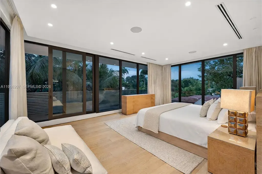 Stunning $14.6 Million Tropical Modern Island Estate Showcases Elite Luxury Living in Miami Beach 14 Front exterior view of modern tropical luxury home in Miami Beach featuring resort-style pool, lush landscaping, glass walls, and contemporary architecture at a $14.6 million island estate.