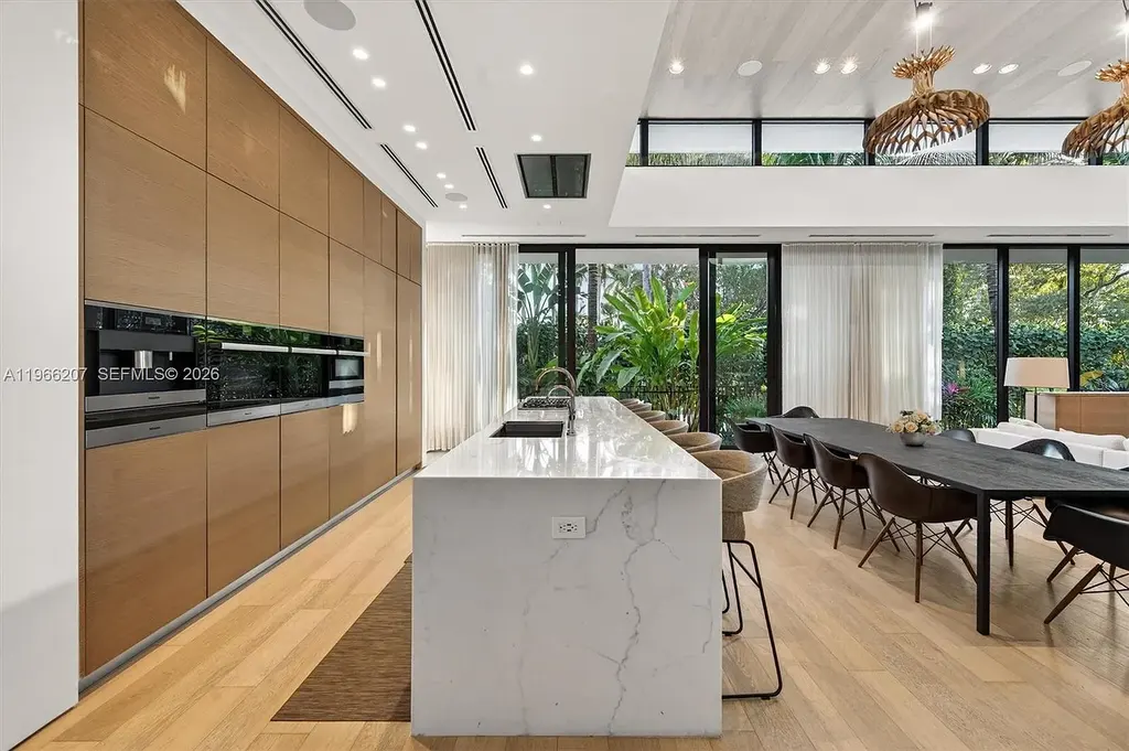 Stunning $14.6 Million Tropical Modern Island Estate Showcases Elite Luxury Living in Miami Beach 8 Front exterior view of modern tropical luxury home in Miami Beach featuring resort-style pool, lush landscaping, glass walls, and contemporary architecture at a $14.6 million island estate.