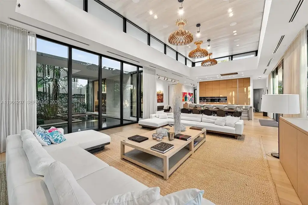 Stunning $14.6 Million Tropical Modern Island Estate Showcases Elite Luxury Living in Miami Beach 7 Front exterior view of modern tropical luxury home in Miami Beach featuring resort-style pool, lush landscaping, glass walls, and contemporary architecture at a $14.6 million island estate.