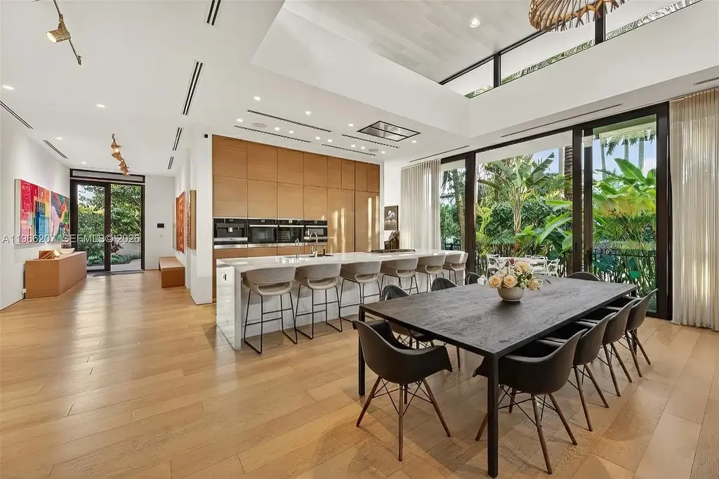 Stunning $14.6 Million Tropical Modern Island Estate Showcases Elite Luxury Living in Miami Beach 9 Front exterior view of modern tropical luxury home in Miami Beach featuring resort-style pool, lush landscaping, glass walls, and contemporary architecture at a $14.6 million island estate.