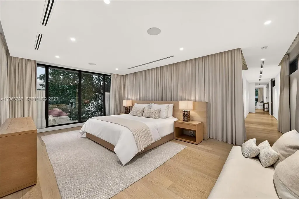 Stunning $14.6 Million Tropical Modern Island Estate Showcases Elite Luxury Living in Miami Beach 12 Front exterior view of modern tropical luxury home in Miami Beach featuring resort-style pool, lush landscaping, glass walls, and contemporary architecture at a $14.6 million island estate.