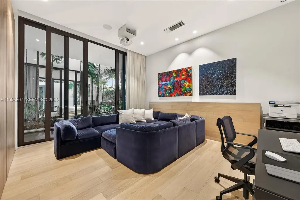 Stunning $14.6 Million Tropical Modern Island Estate Showcases Elite Luxury Living in Miami Beach 11 Front exterior view of modern tropical luxury home in Miami Beach featuring resort-style pool, lush landscaping, glass walls, and contemporary architecture at a $14.6 million island estate.