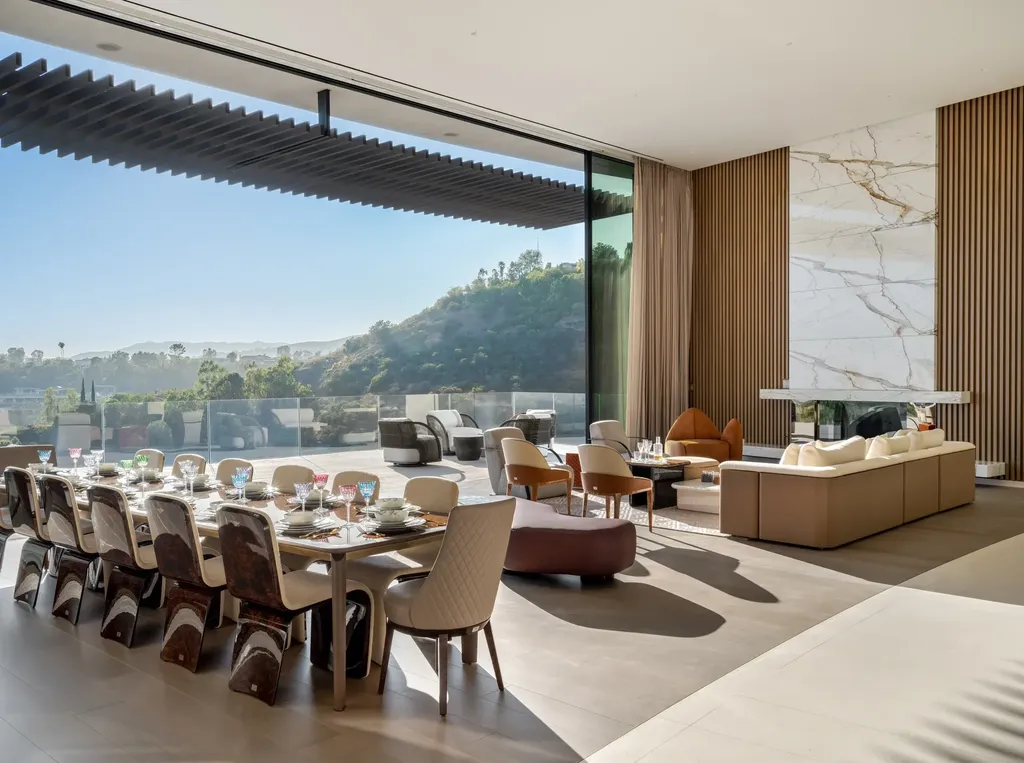La Vue Mansion Commands $177 Million as a Singular Contemporary Icon in Bel Air 2 Open plan living and dining area inside La Vue Mansion in Bel Air featuring floor to ceiling glass contemporary furnishings Calacatta stone fireplace and seamless indoor outdoor flow.