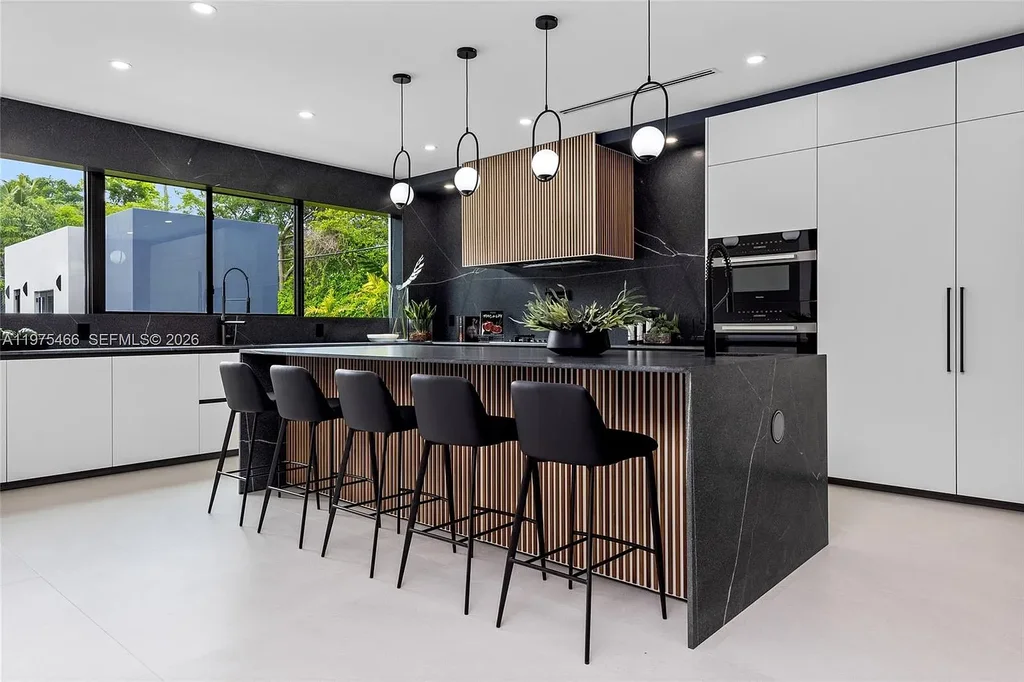 $10.4 Million Spectacular Modern Estate Redefining Luxury Living in Prime Pinecrest Real Estate 8 Chef’s kitchen with premium appliances and oversized island at 6445 SW 129th Ter Pinecrest
