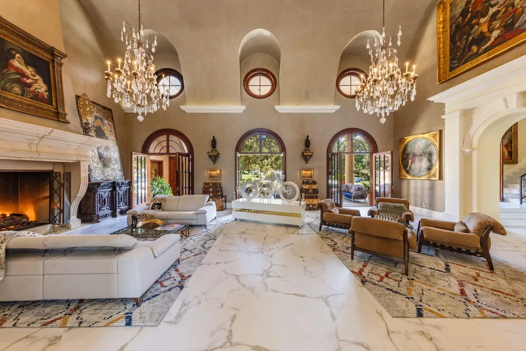 A $68,000,000 Beverly Park Estate Signals a New Era of Ultra-Scale Luxury in Los Angeles 5 Grand living room inside a Beverly Park estate in Los Angeles featuring high ceilings, chandeliers, marble flooring, and classic architectural details
