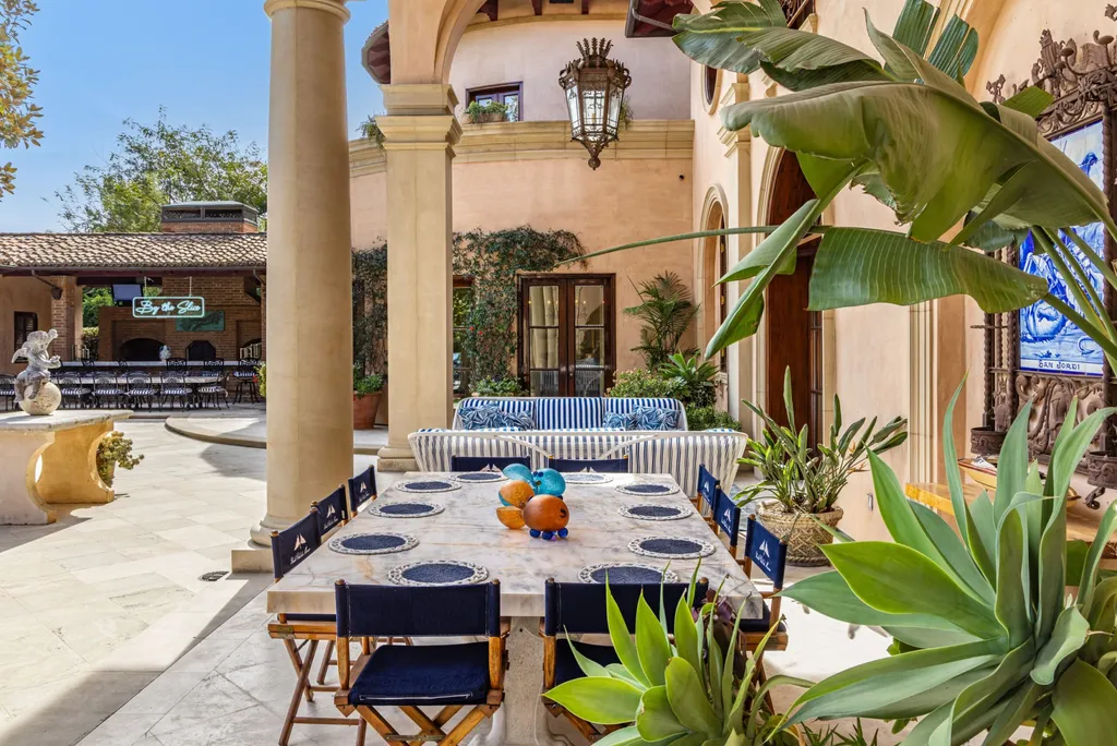 A $68,000,000 Beverly Park Estate Signals a New Era of Ultra-Scale Luxury in Los Angeles 13 Outdoor dining area in a Beverly Park estate in Los Angeles featuring a courtyard patio, marble table, and lush landscaping