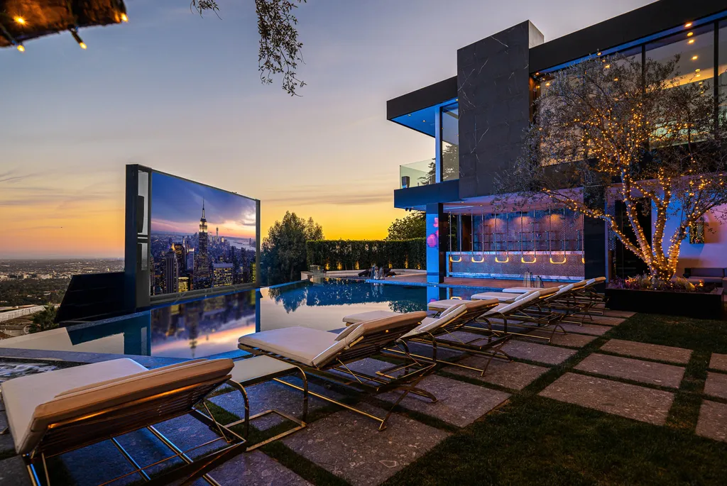 Most Expensive Homes in California 19 infinity pool with outdoor screen overlooking Los Angeles skyline at sunset