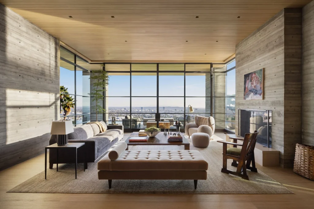 Most Expensive Homes in California 13 modern living room with concrete walls and floor to ceiling glass overlooking Los Angeles