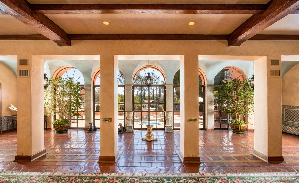 The Hearst Estate in Beverly Hills: A Historic Landmark Where Hollywood Legacy Meets Market Reality 4 The Hearst Estate in Beverly Hills featuring arched loggia with terracotta floors, wood beams, and garden views