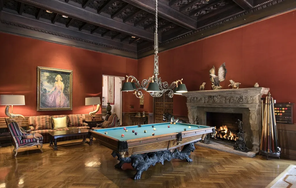 The Hearst Estate in Beverly Hills: A Historic Landmark Where Hollywood Legacy Meets Market Reality 11 The Hearst Estate in Beverly Hills featuring billiards room with carved stone fireplace, wood flooring, and classic game table