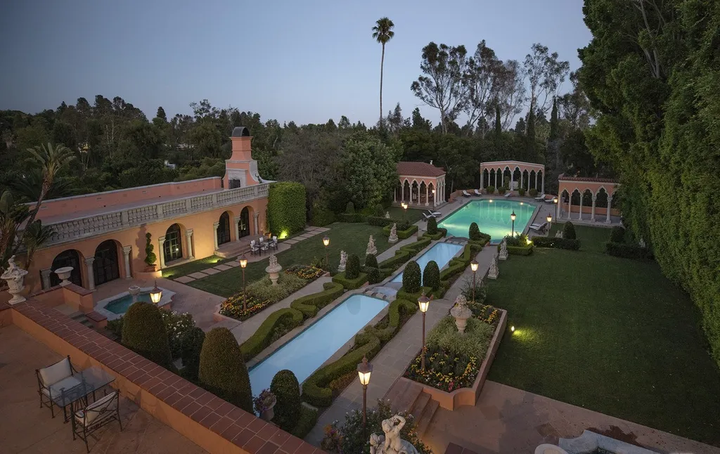 The Hearst Estate in Beverly Hills: A Historic Landmark Where Hollywood Legacy Meets Market Reality 15 The Hearst Estate in Beverly Hills featuring formal gardens, reflecting pools, and illuminated outdoor grounds at dusk