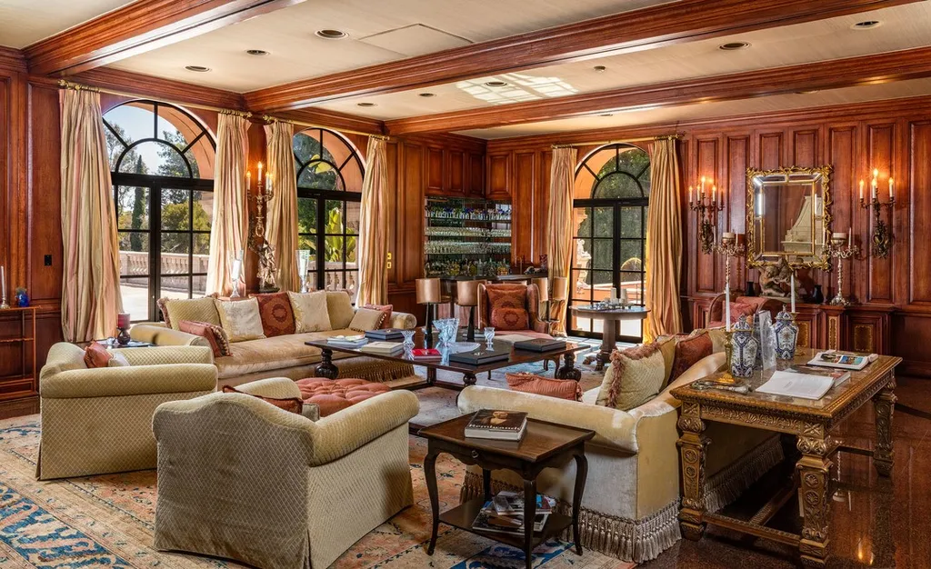 The Hearst Estate in Beverly Hills: A Historic Landmark Where Hollywood Legacy Meets Market Reality 5 The Hearst Estate in Beverly Hills featuring formal living room with wood-paneled walls, arched windows, and classic luxury furnishings